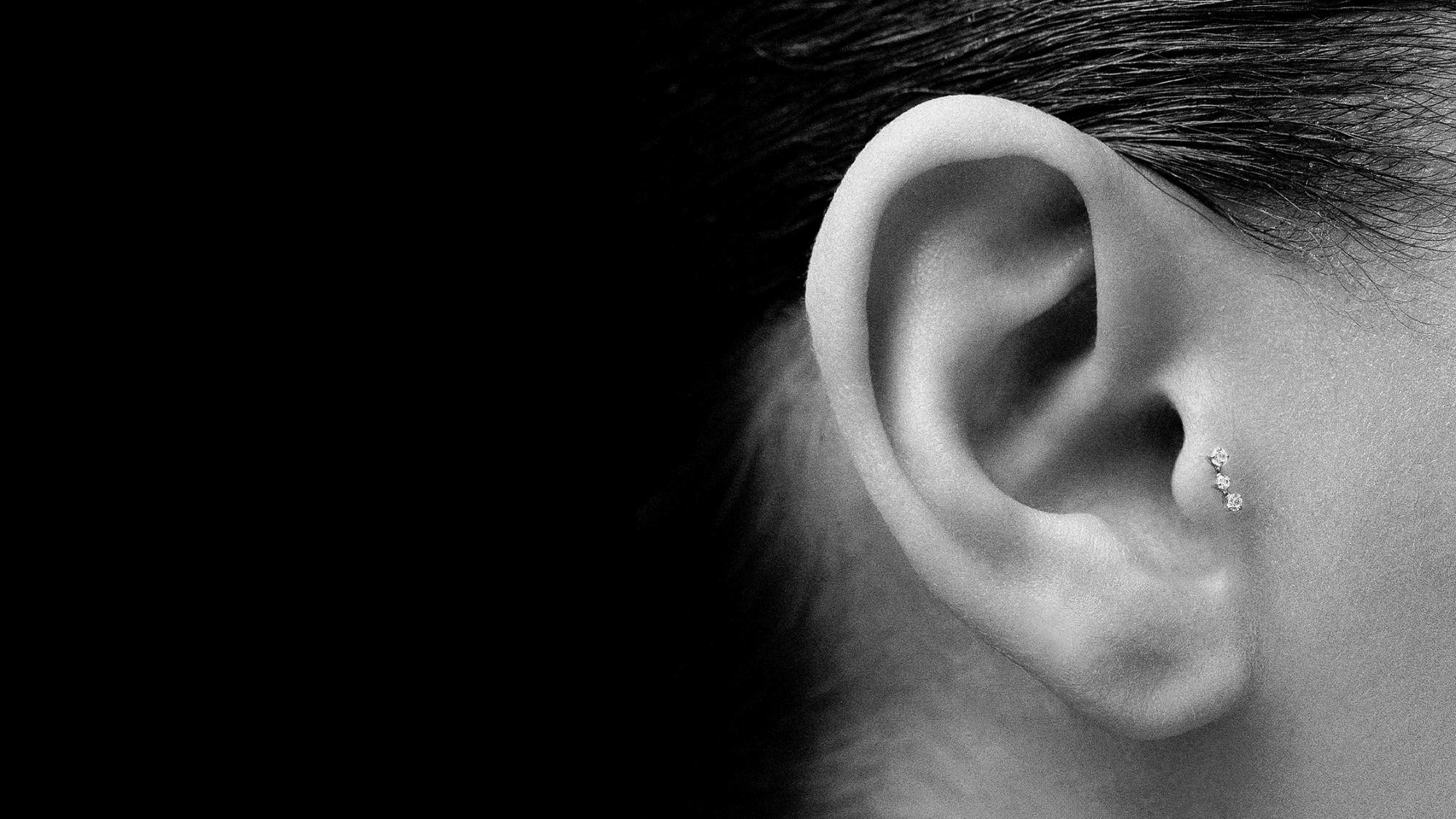 Une femme porte un bijou d'oreille mini-orion de chez Nébuleuse