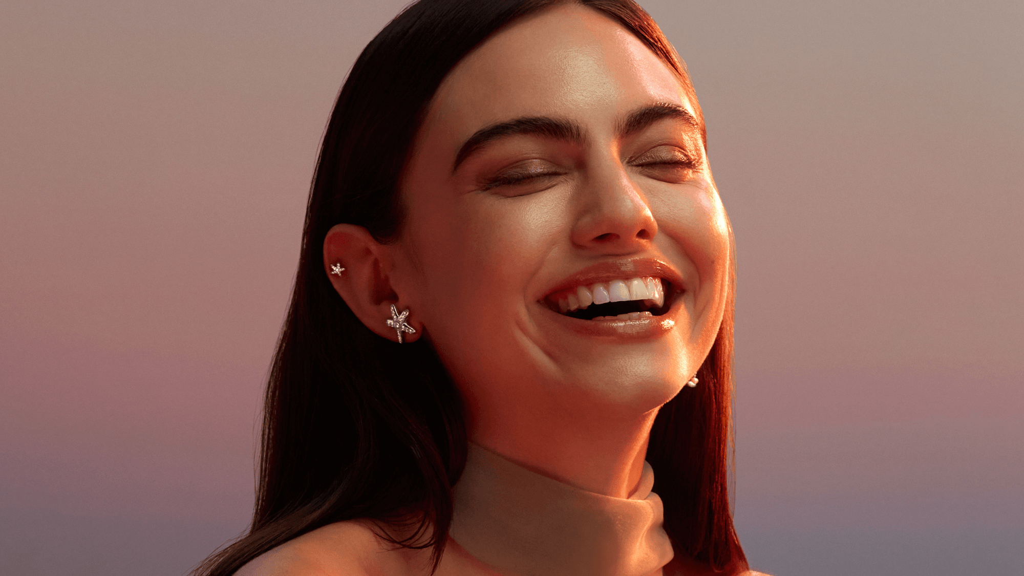 Une femme sourit elle porte des bijoux nébuleuse aux oreilles