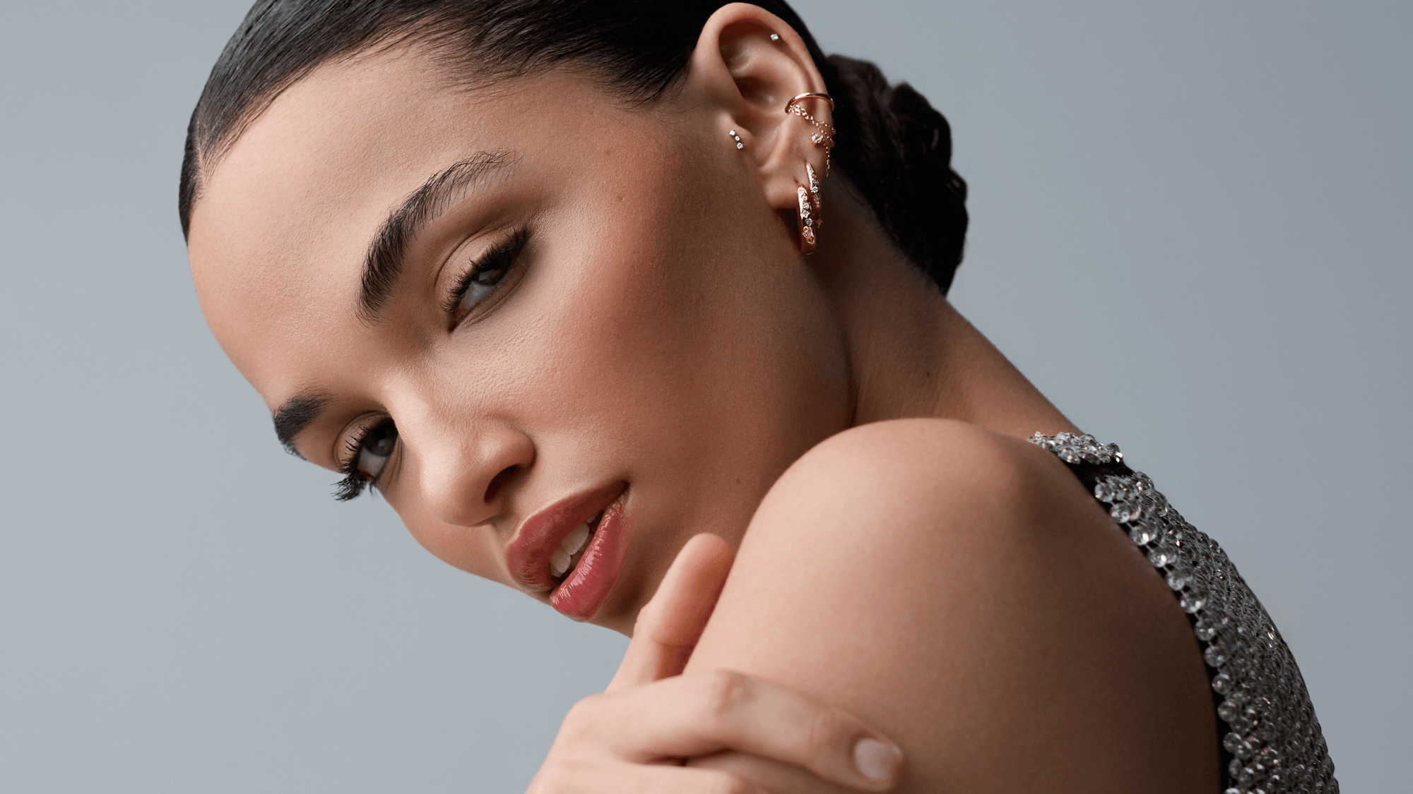 Une femme avec des boucles d'oreille regarde l'objectif