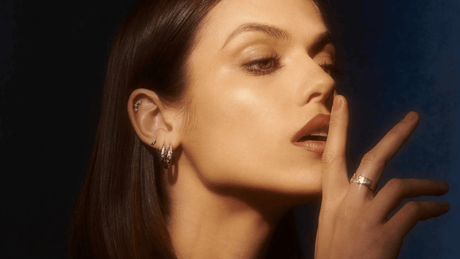 Femme souriante portant des boucles d'oreilles avec main proche du visage