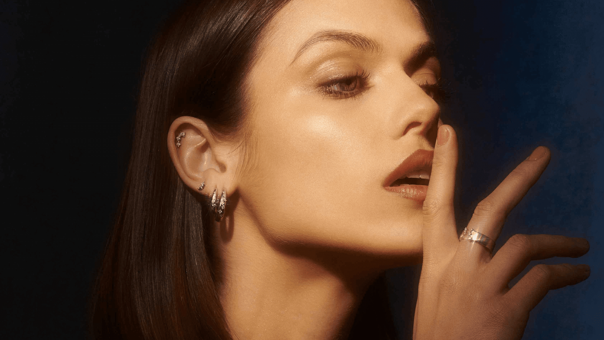 Femme souriante portant des boucles d'oreilles avec main proche du visage