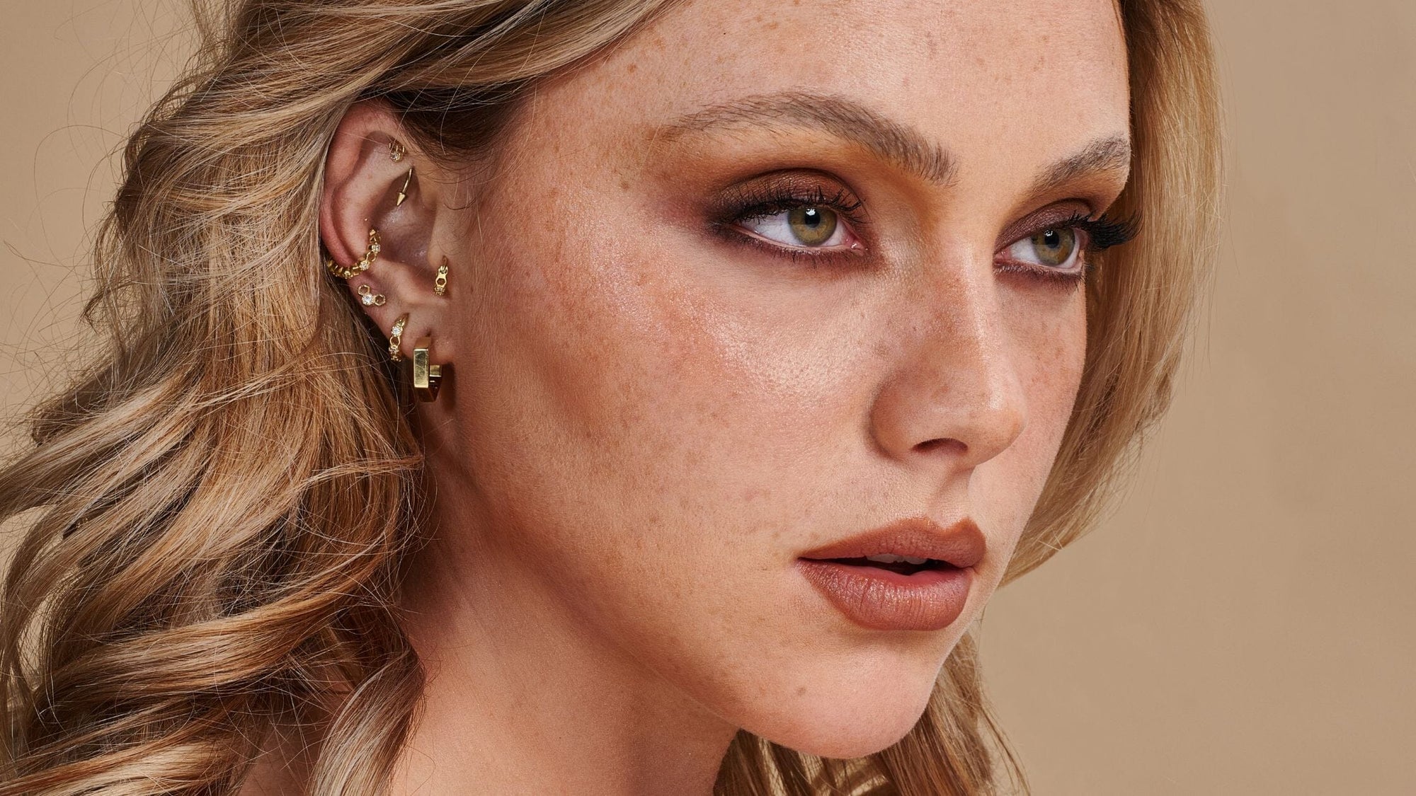 Femme blonde qui porte des boucles d'oreilles dorées
