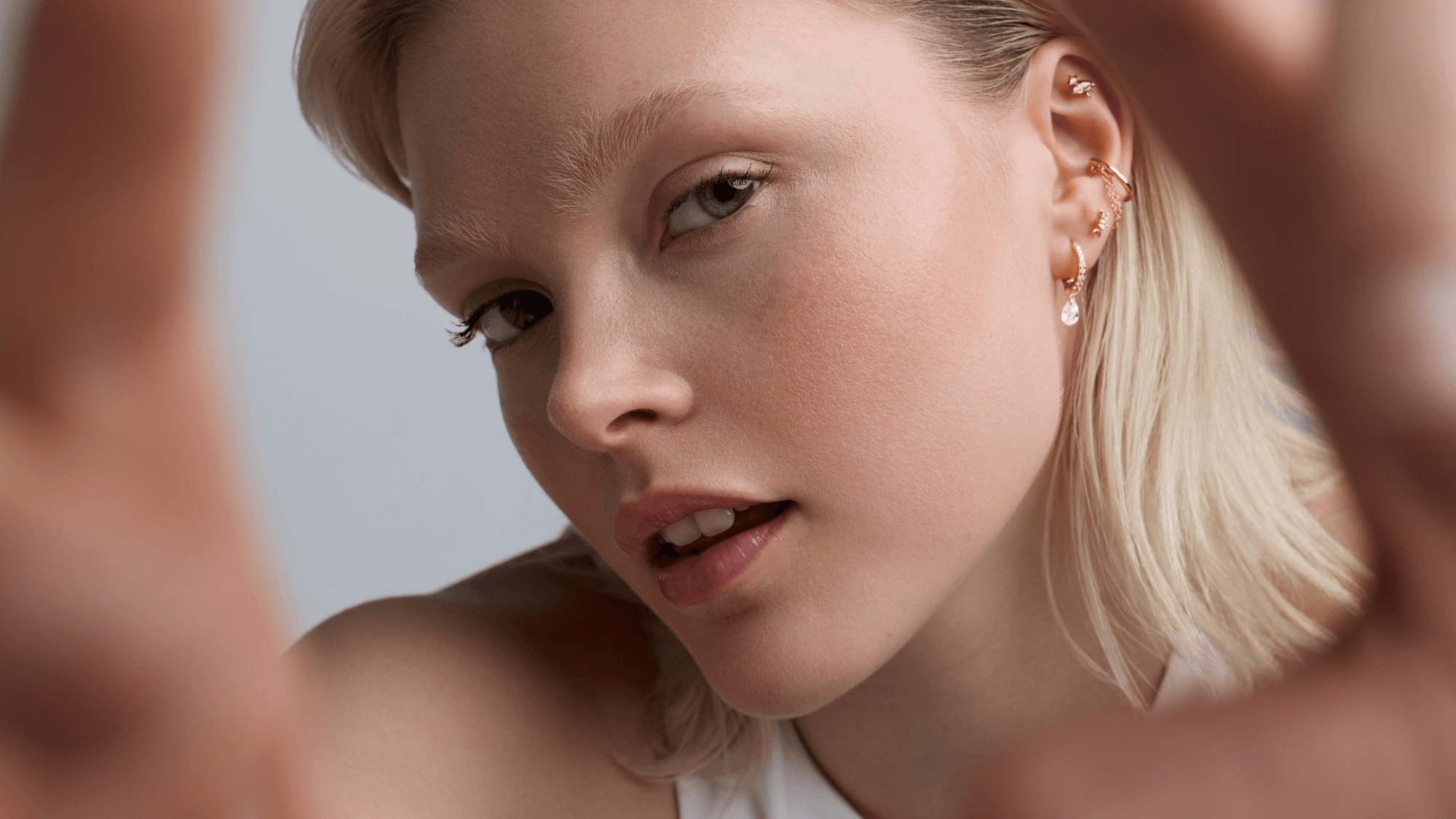Une femme en gros plan porte des bijoux d'oreille en regardant l'objectif