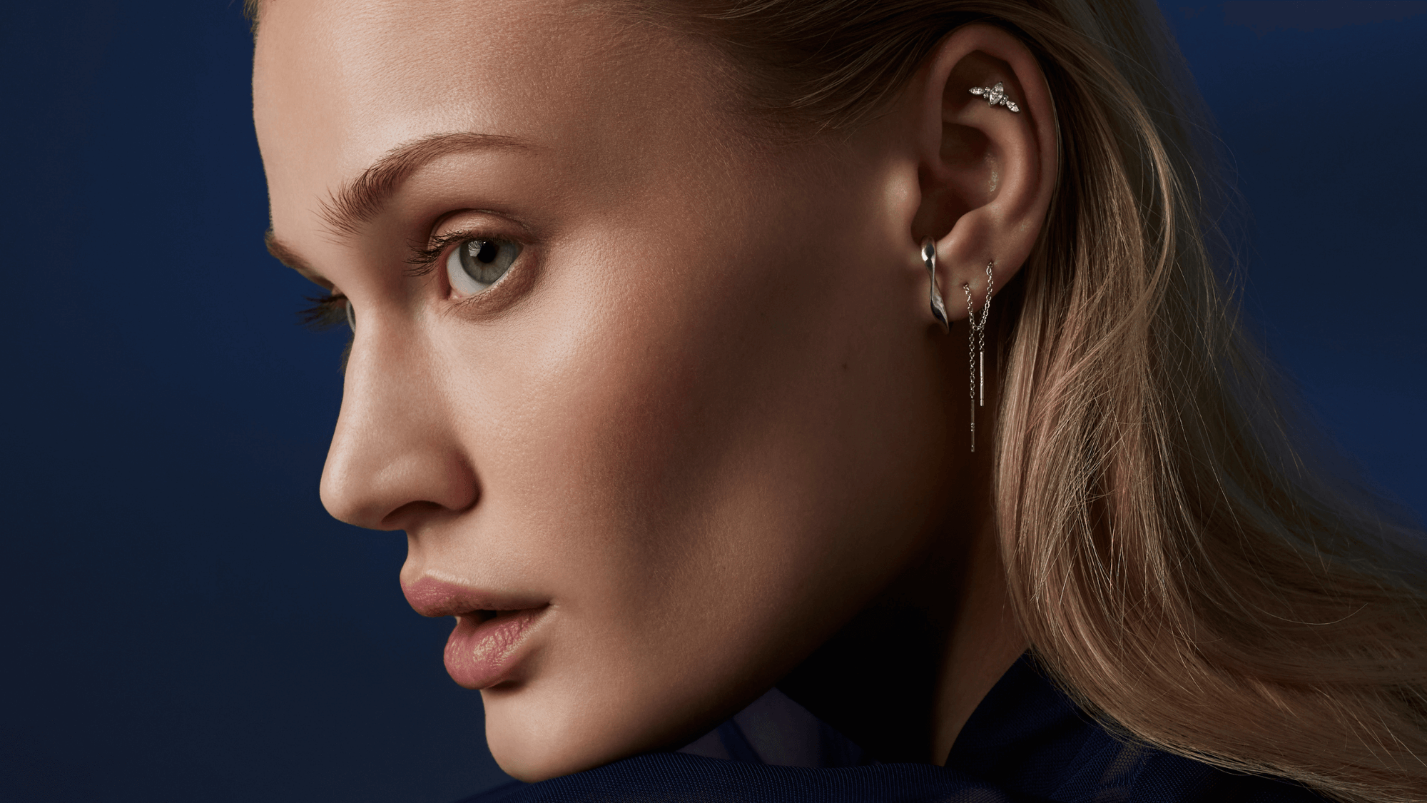 Une femme de profil porte des bijoux