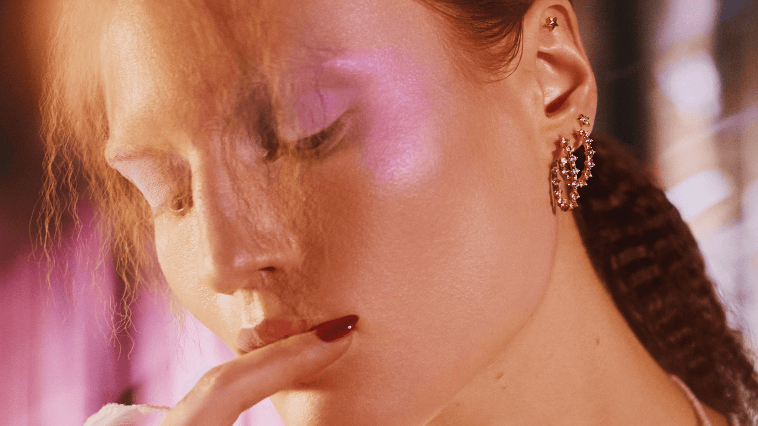 Une femme de profil porte des boucles d'oreilles