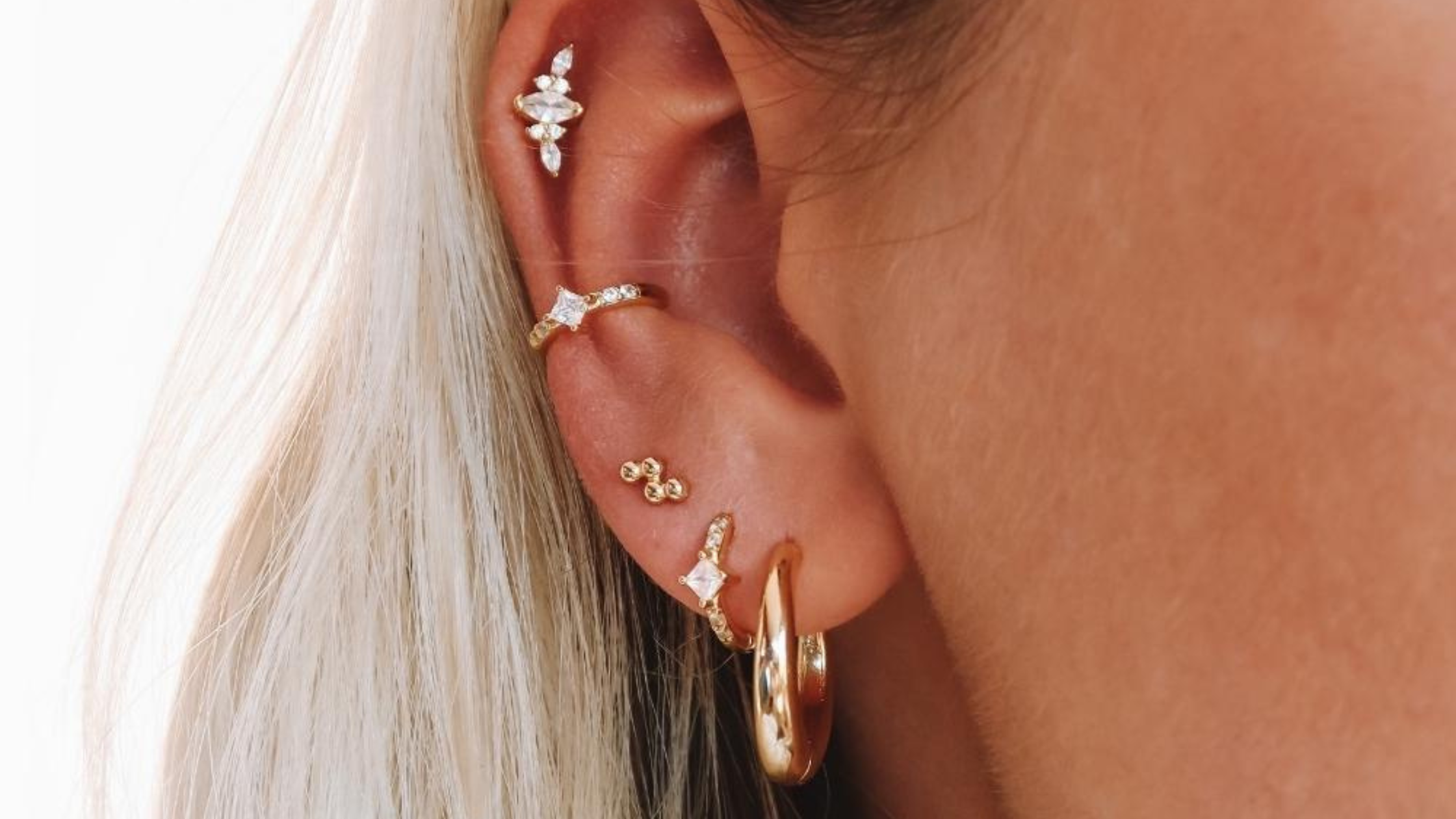 Oreille de femme avec plusieurs boucles et un piercing à l'hélix 