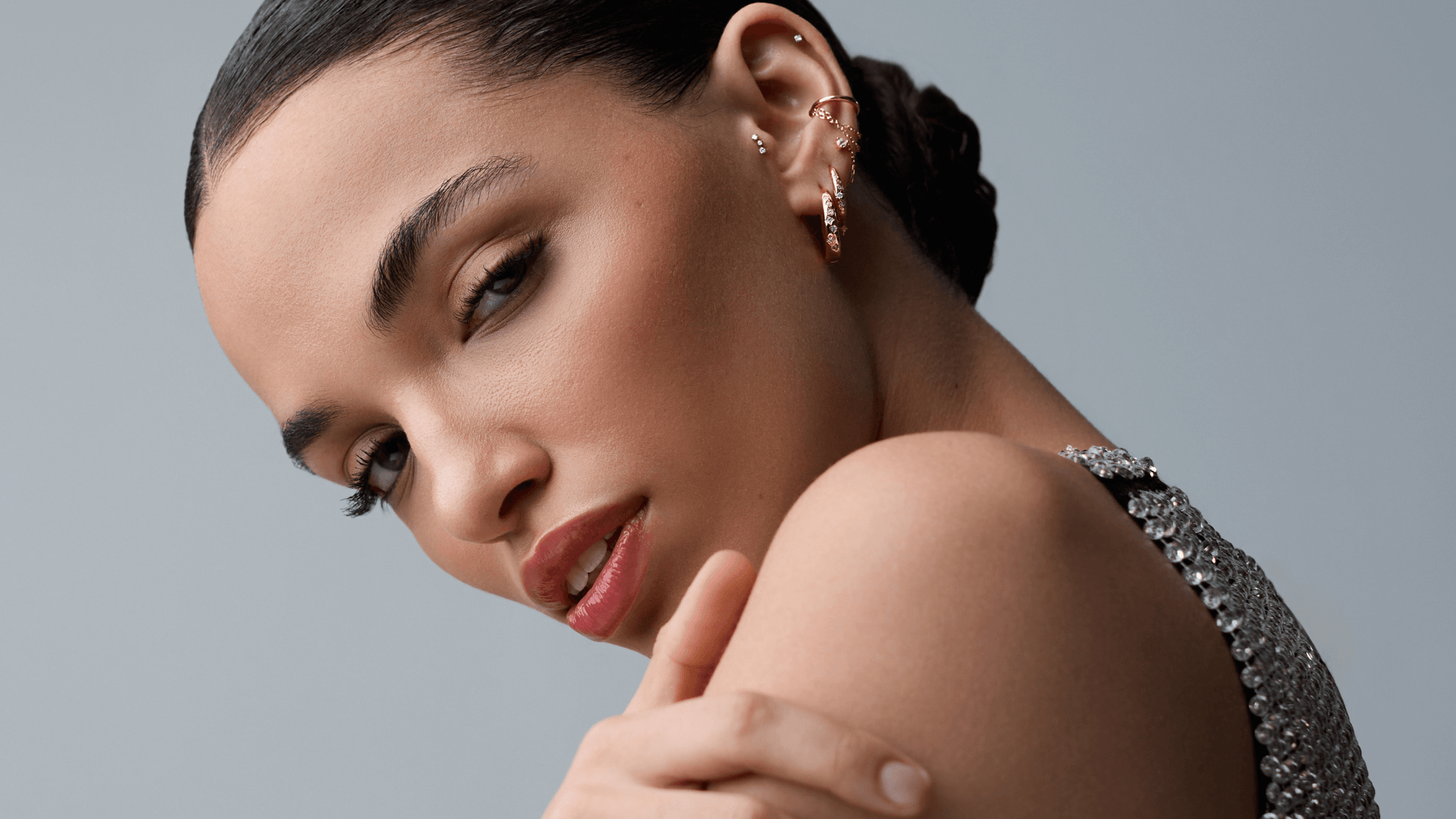 Une femme avec des boucles d'oreille regarde l'objectif 