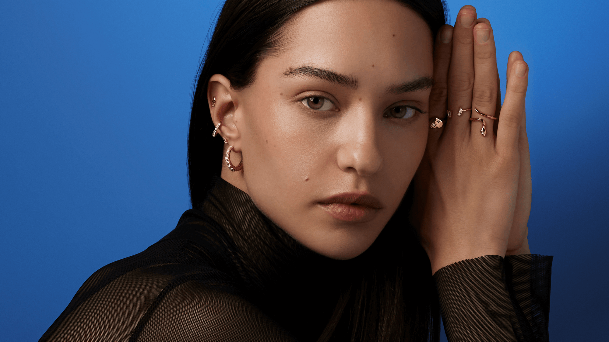 Une femme portant des bijoux regarde l'objectif 